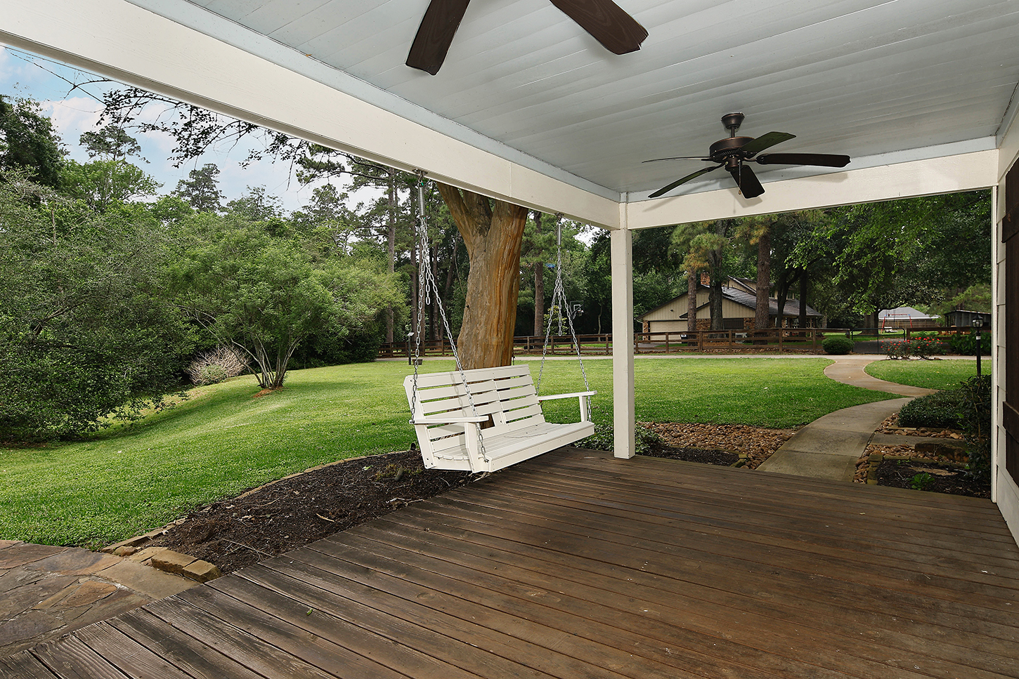 Guest house porch with hanging swing and lawn view