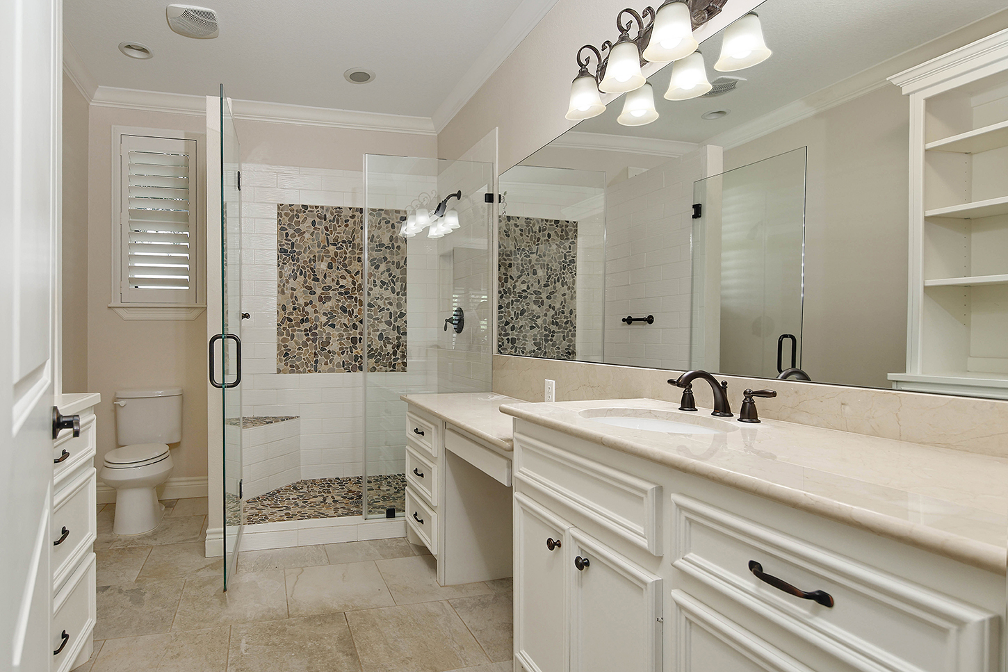 Primary bath with walk-in shower and pebble tile accent