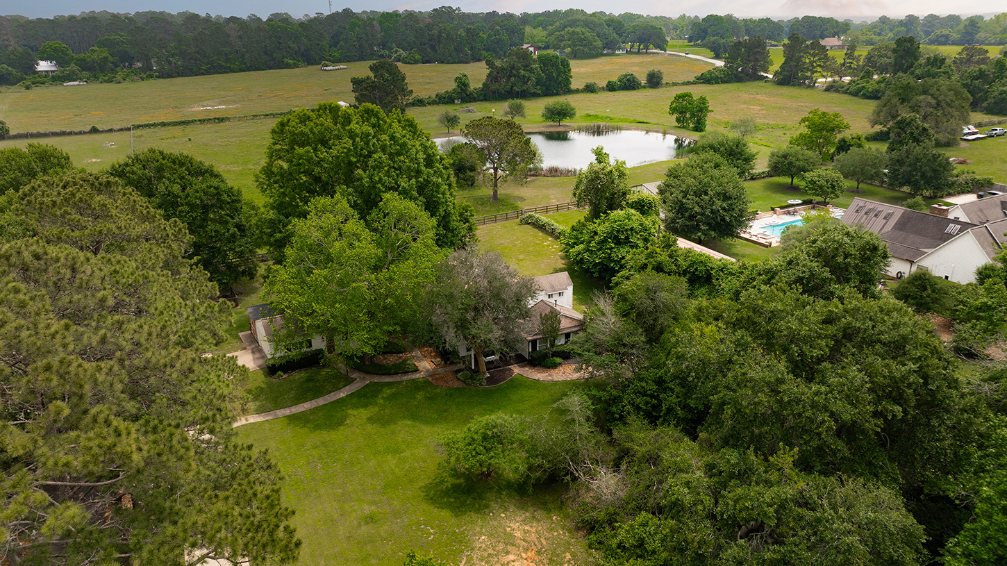Aerial view of the cottage with pond and pool beyond