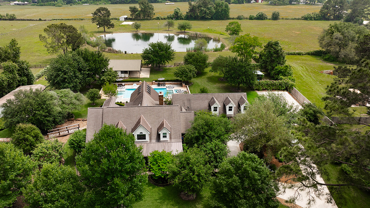 Aerial overview of the estate, pool, pond, and surrounding acreage