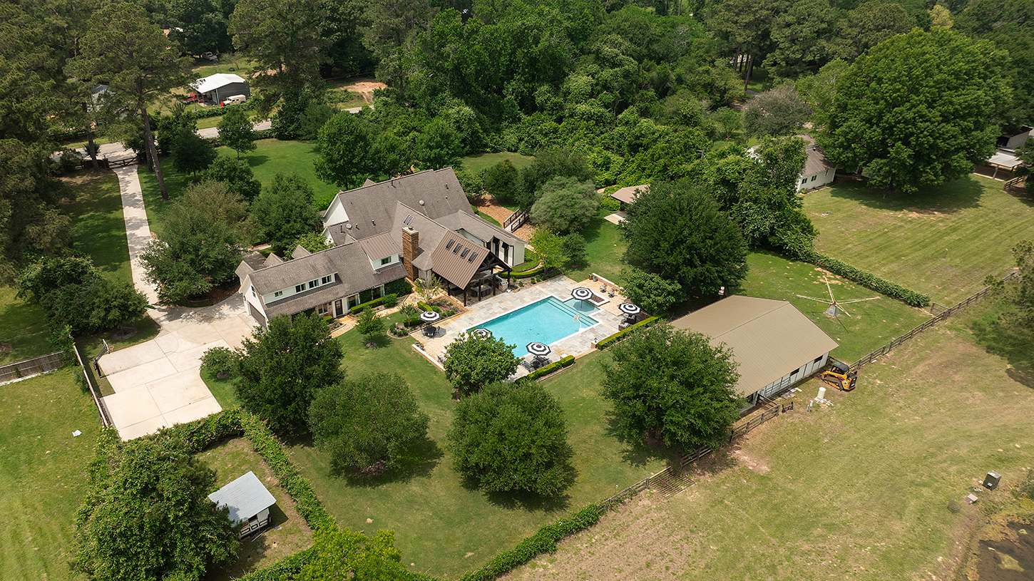 Aerial view of the main house, pool, and stable