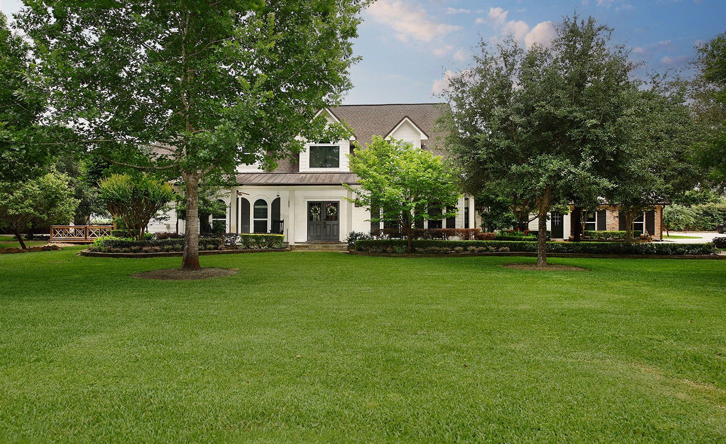 Full front elevation of the estate across the manicured lawn