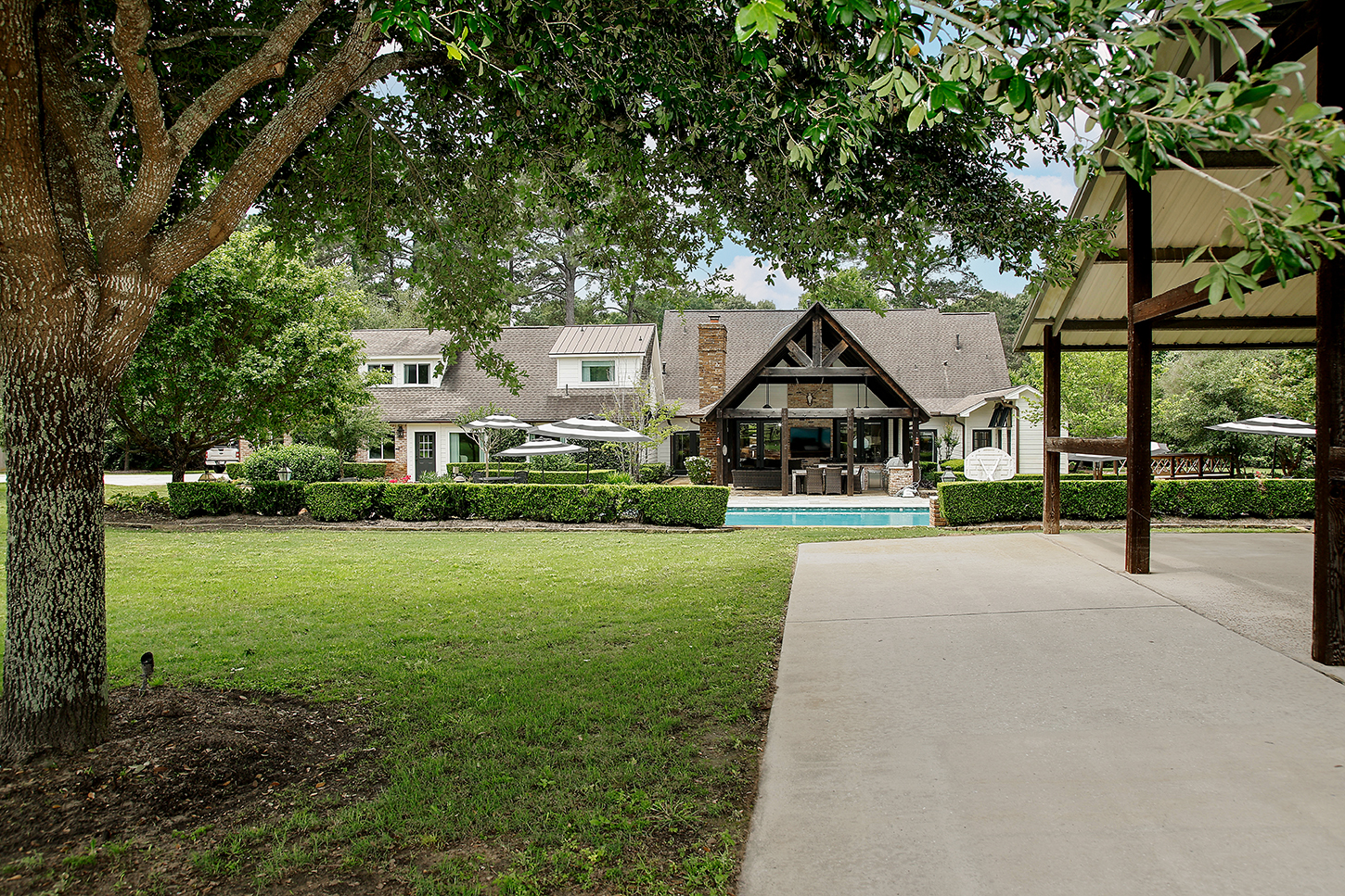 Rear view of the estate with pool and pavilion across the lawn