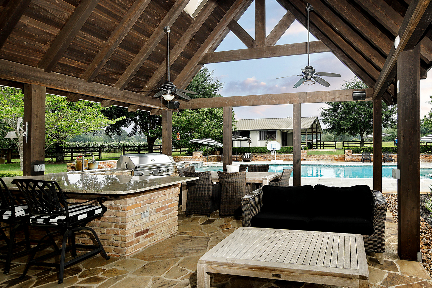 Covered outdoor kitchen with grill beside the pool
