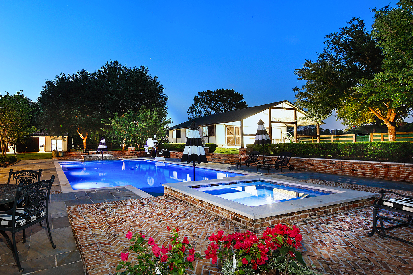 Pool and raised spa at twilight with stable beyond