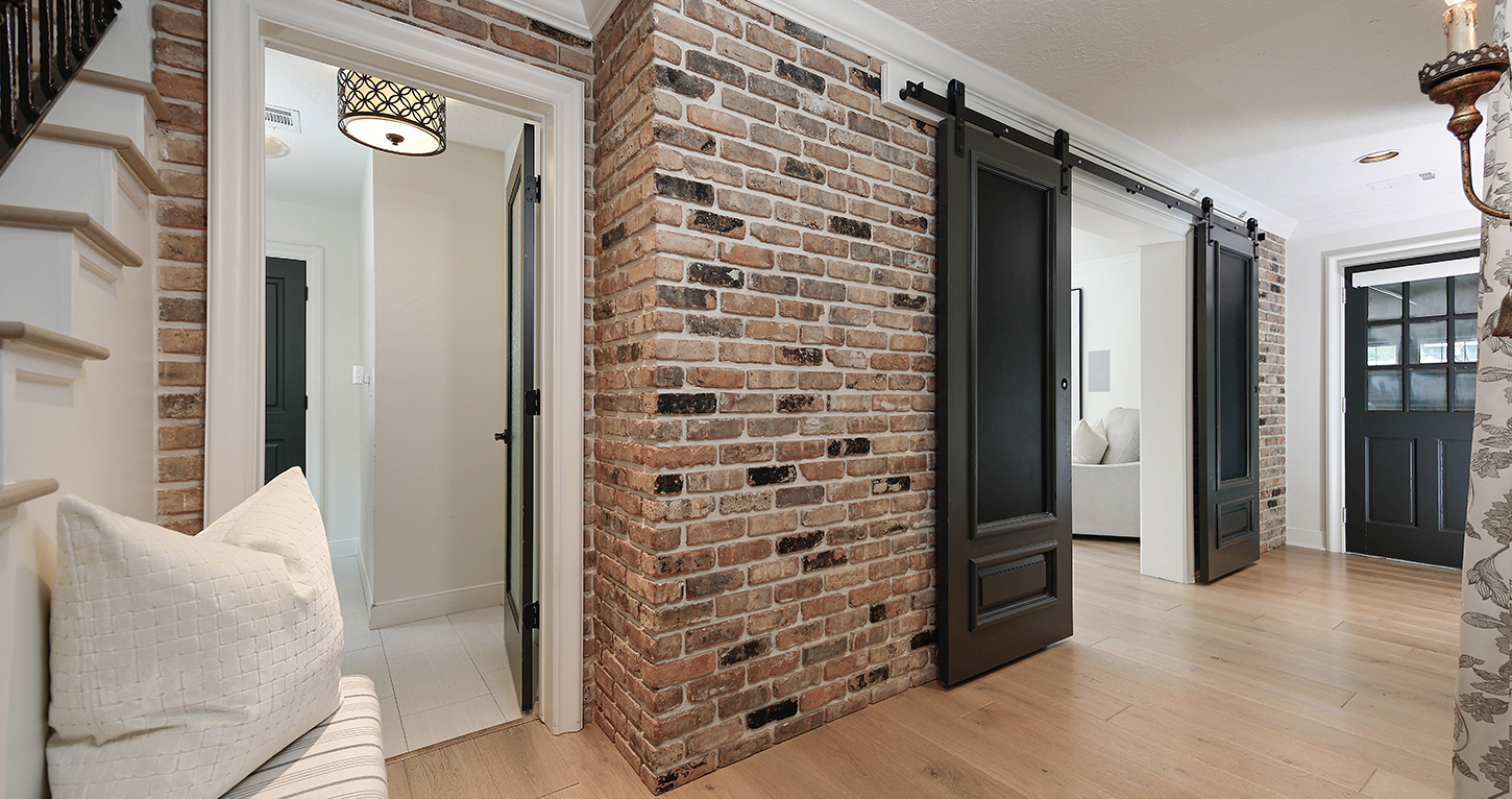 Reclaimed brick hallway with sliding barn doors