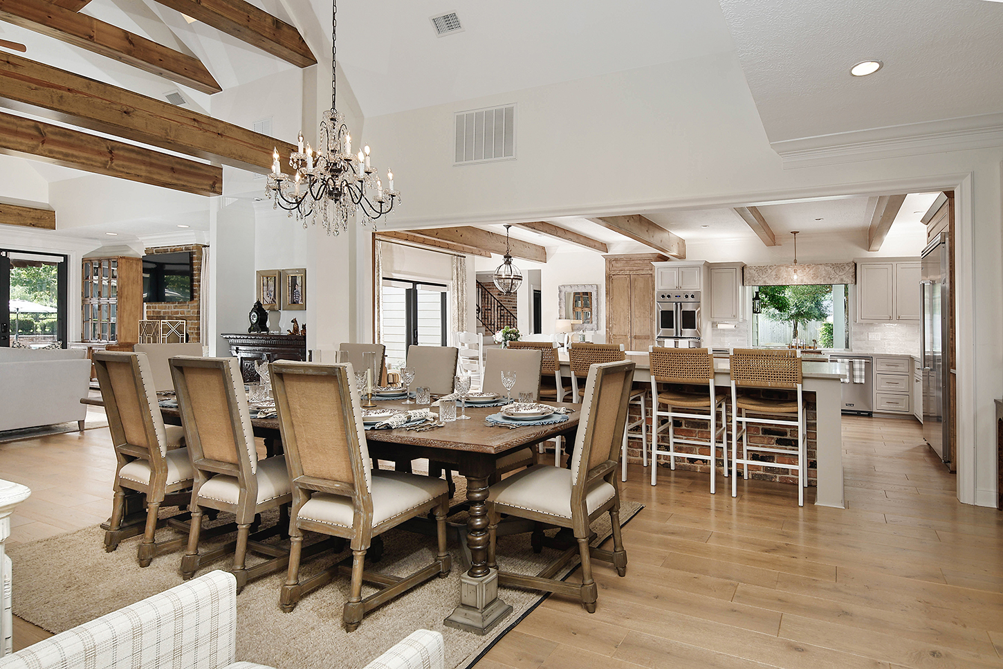 Open dining room flowing to kitchen with beamed ceilings