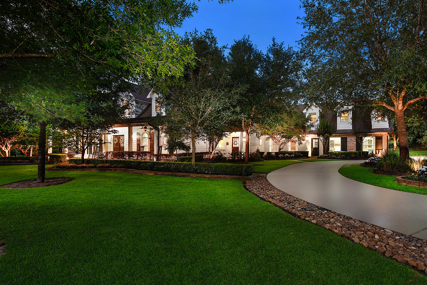 Twilight exterior of the main house along the curved driveway