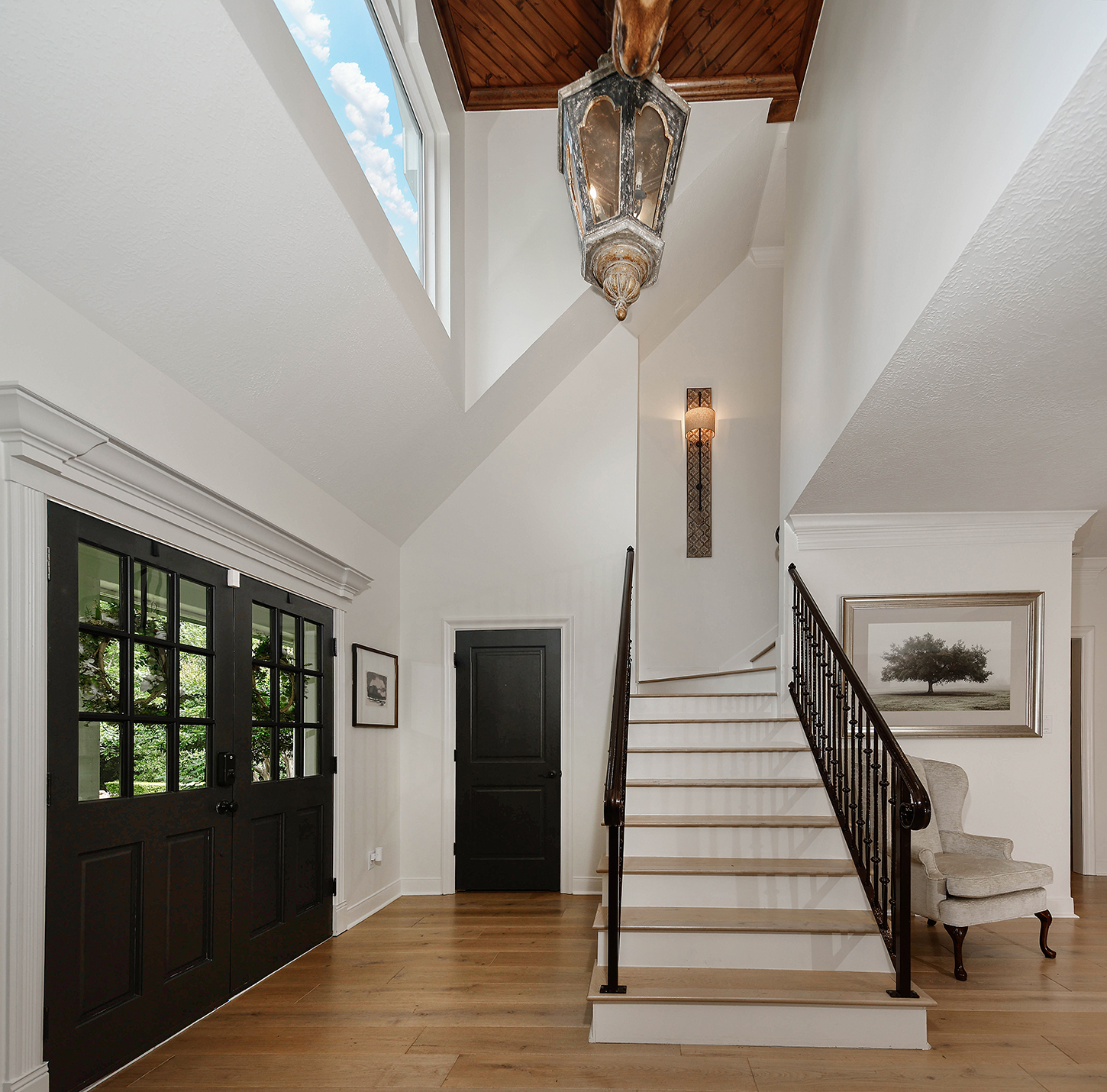 Two-story foyer with antique lantern and wood ceiling