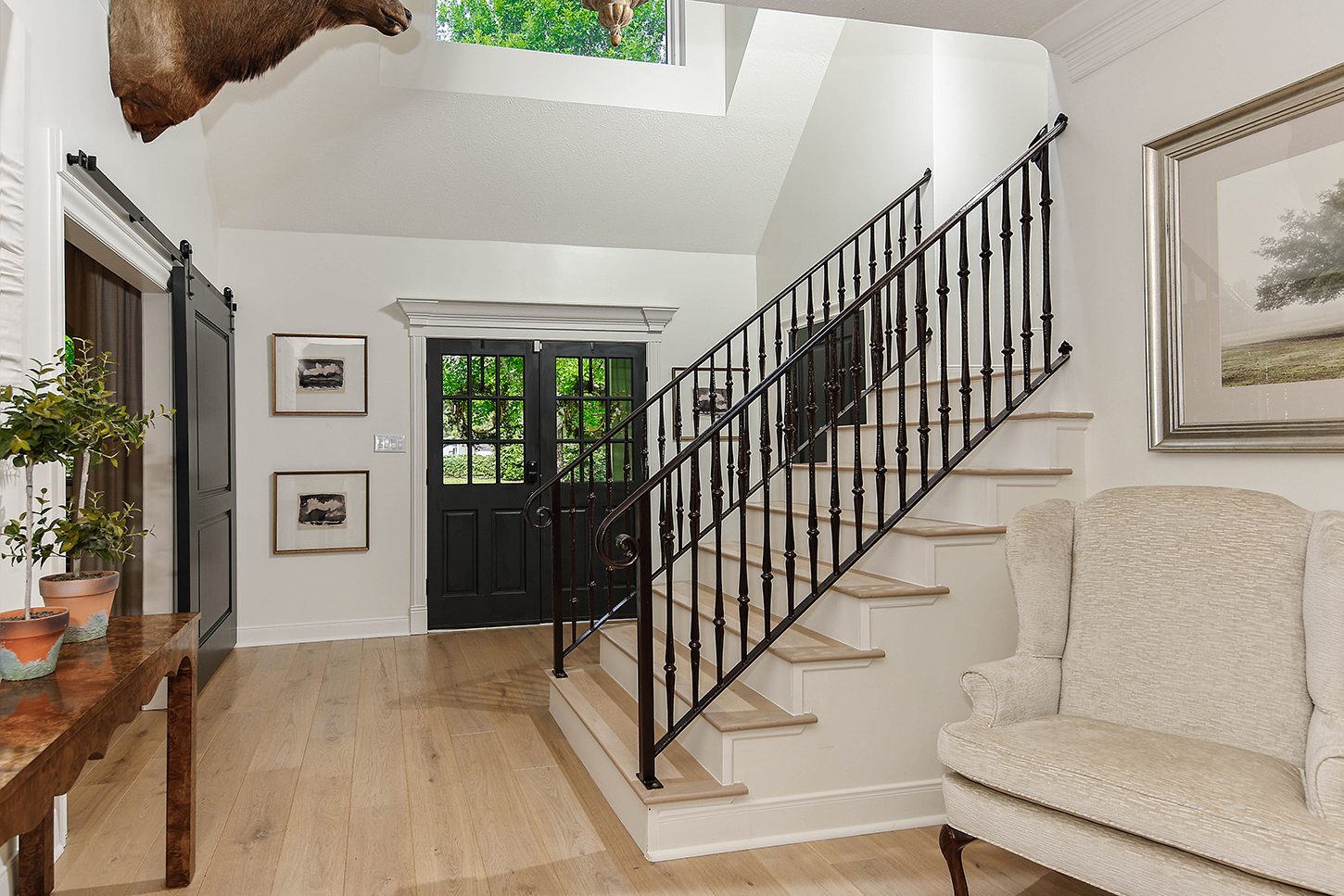 Foyer with iron-spindle staircase and barn door