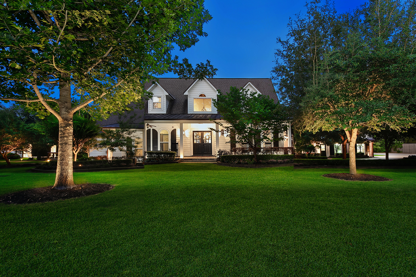 Twilight view of the main house across the front lawn