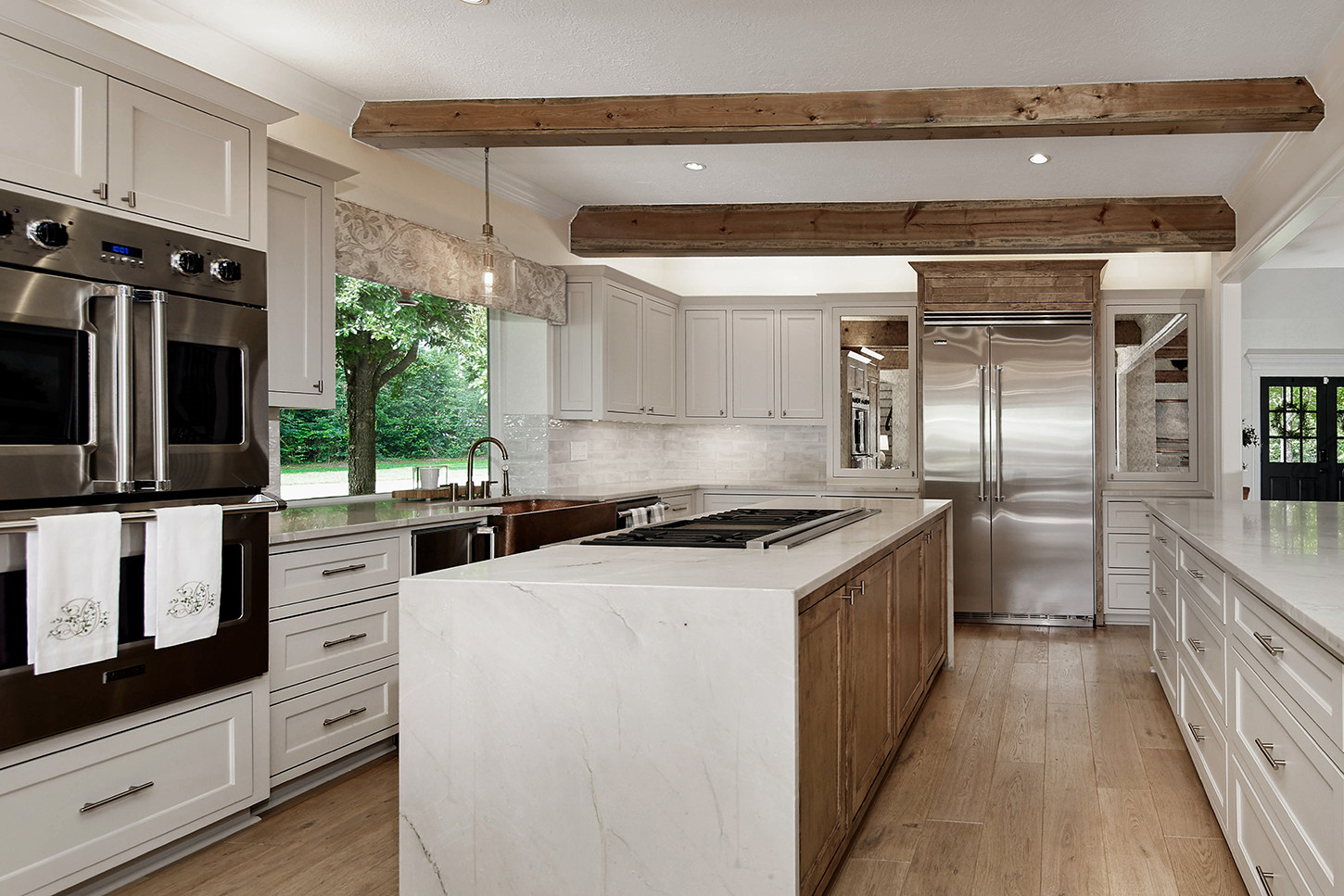 Chef's kitchen with marble waterfall island and copper sink