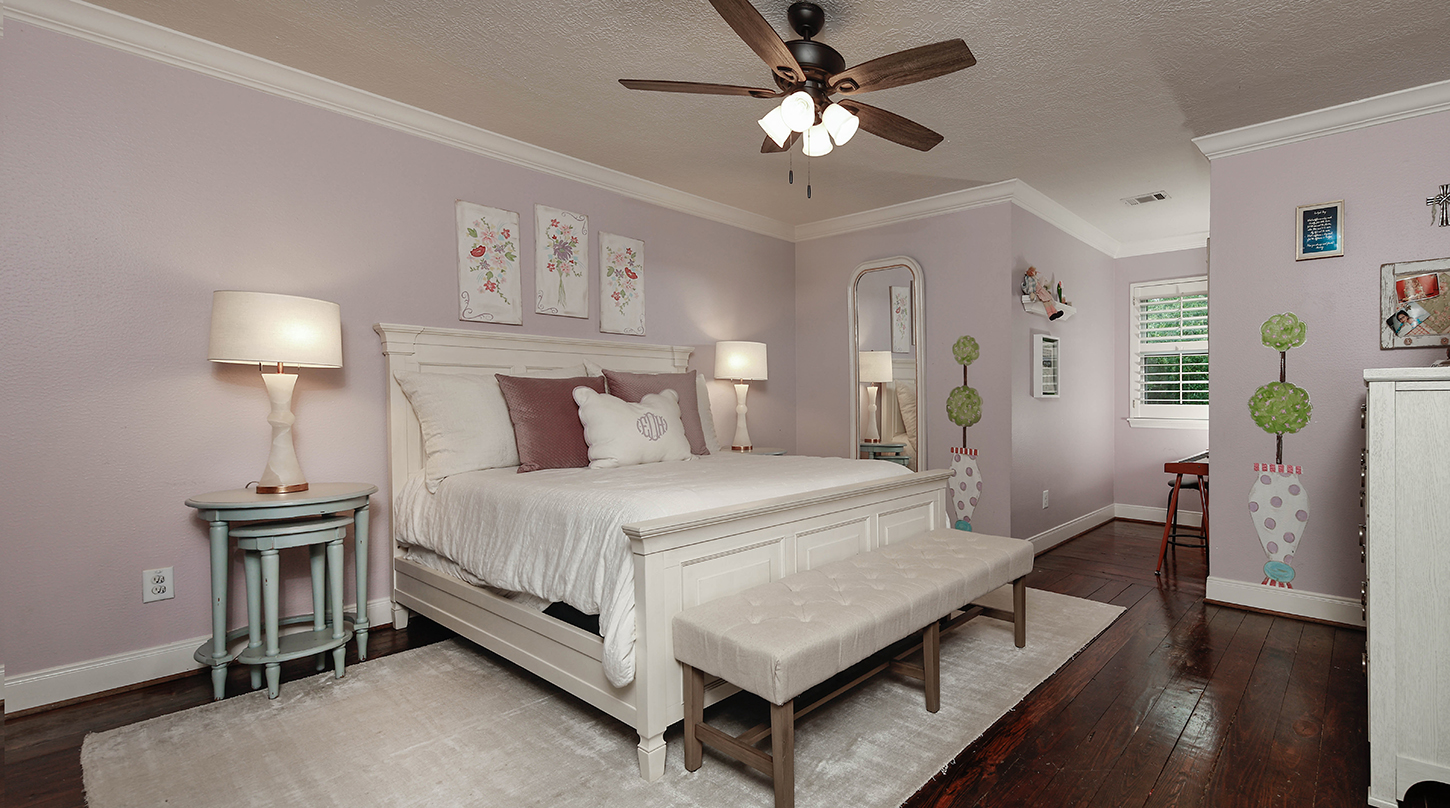 Lavender bedroom with writing desk and white bed