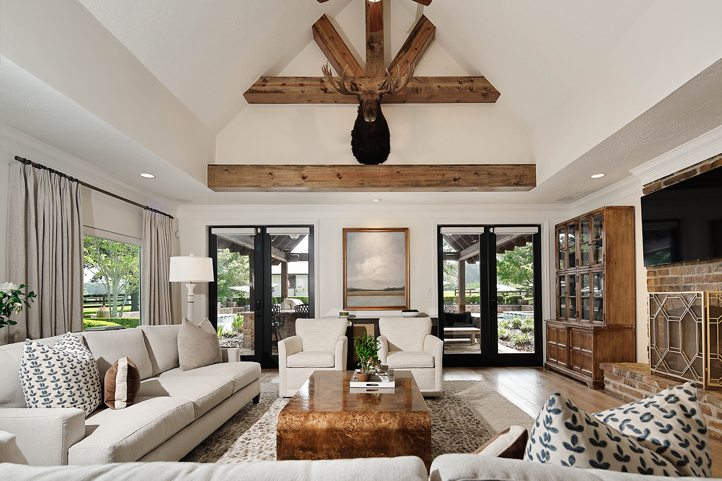 Vaulted family room with beamed trusses and brick fireplace