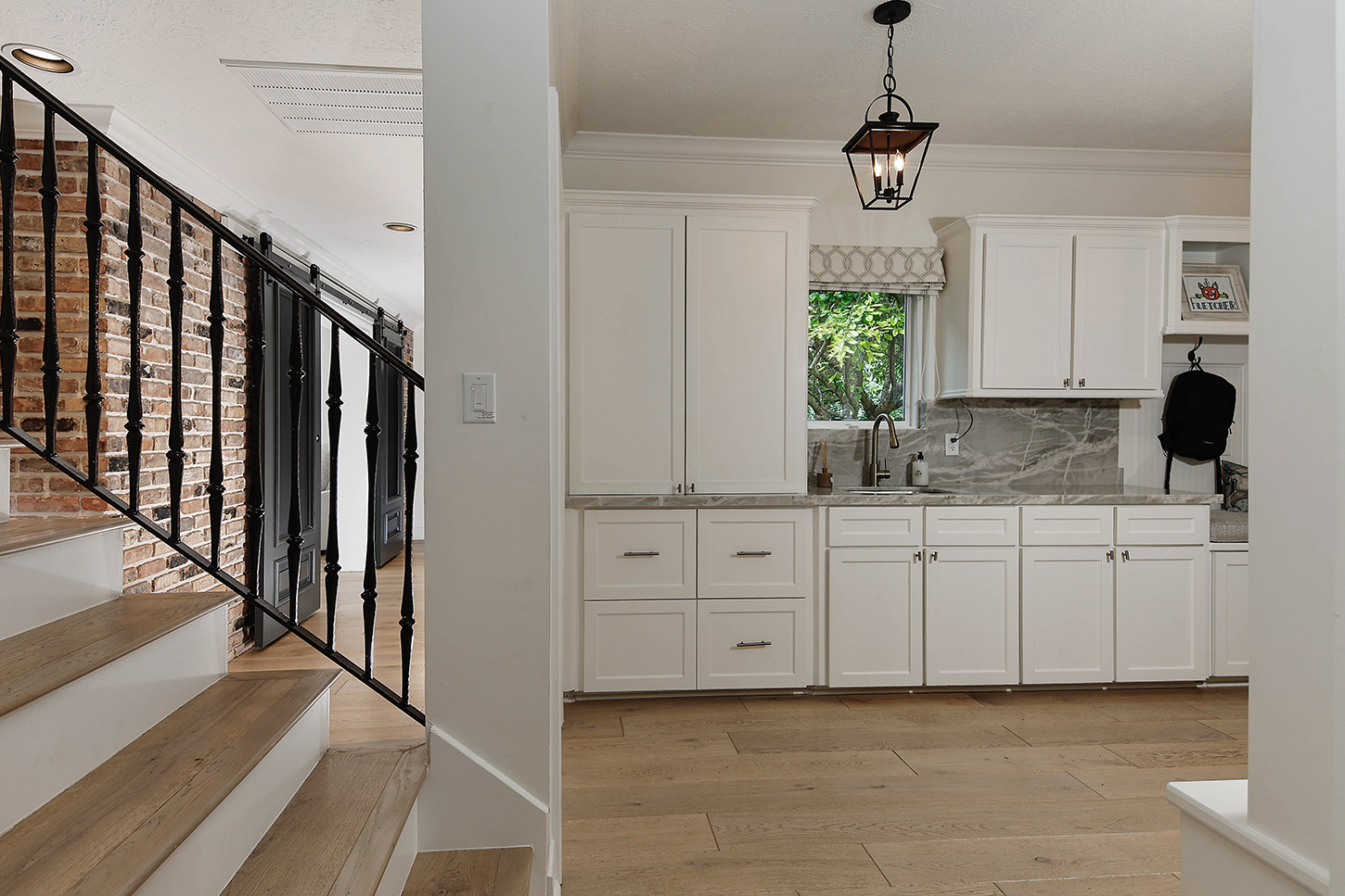 Back staircase with brick wall and mudroom kitchenette
